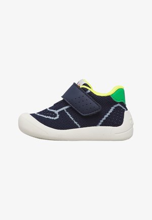 Chaussure bébé bleu marine avec semelle blanche, col jaune fluo, talon vert et une bride perforée à scratch pour une fixation facile.