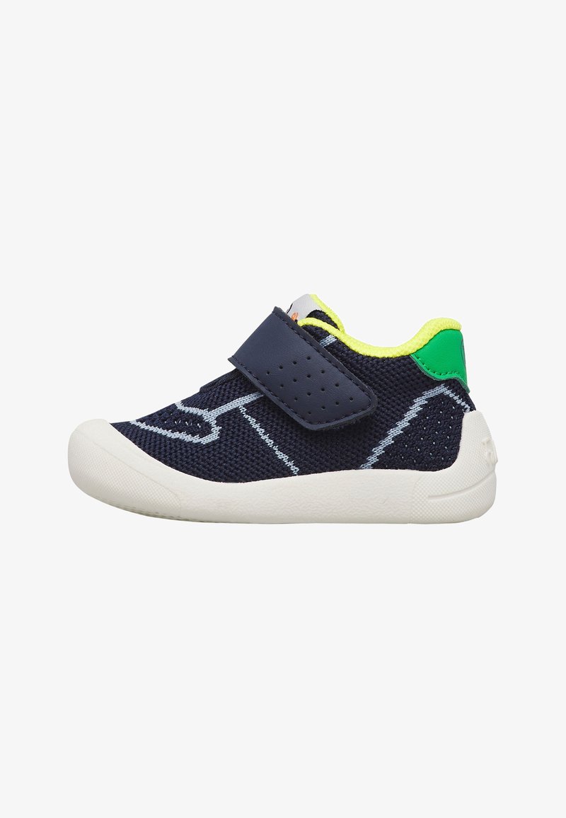 Chaussure bébé bleu marine avec semelle blanche, col jaune fluo, talon vert et une bride perforée à scratch pour une fixation facile.