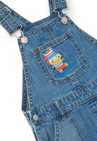 Jeanslatzhosen mit verstellbaren Trägern, distressed Optik, blauer Farbe, mit einem gestickten Charakter auf der Vordertasche.