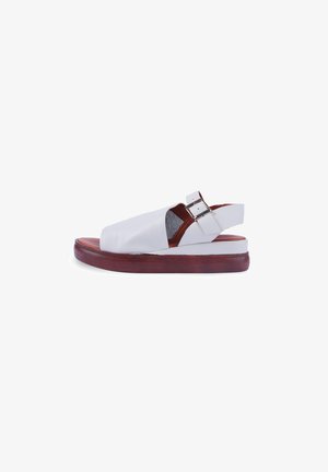 Sandale en cuir blanc avec un design à bout ouvert, semelle en bois brun et sangle ajustable avec une boucle en argent.