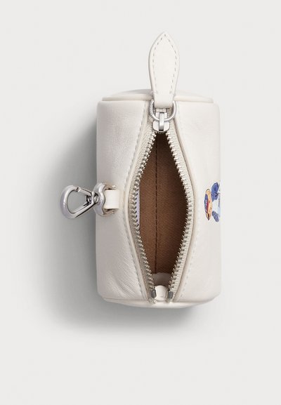 Baltas odinis cilindrinis maišelis su užtrauktuku, rudas vidus ir nedidelis dekoratyvinis piešinys vienoje pusėje.