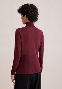 Maglione bordo a maniche lunghe con colletto a risvolto, vestibilità slim, tessuto a maglia leggero, texture liscia, con polsini aderenti e scollo alto.
