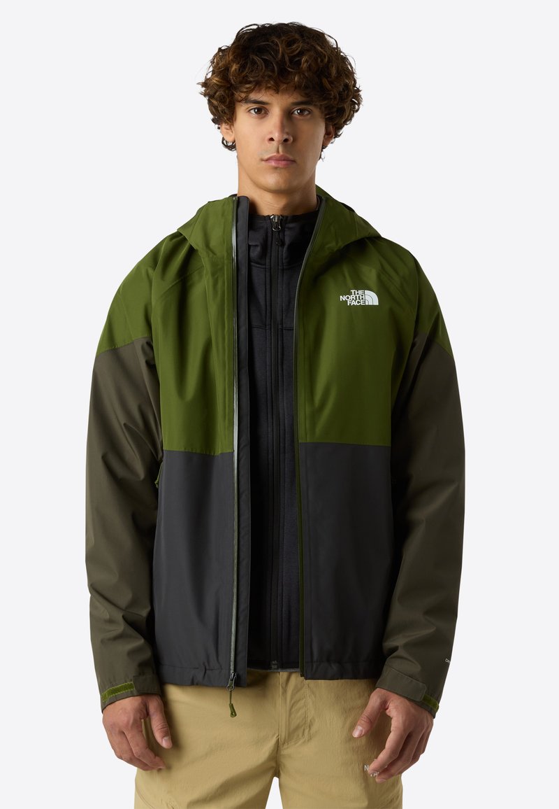 Giacca con cappuccio verde e nera con chiusura zip, realizzata in un tessuto leggero e resistente all'acqua; presenta blocchi di colore contrastanti e logo.