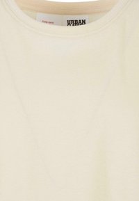 Ljust beige bomulls t-shirt med rund halsringning, detaljer med minimal sömnad och en etikett med texten "URBAN CLASSICS."