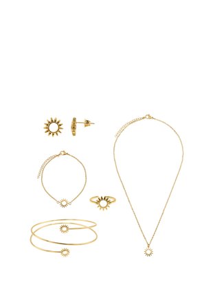 Gold jewelry set featuring sun-shaped designs including earrings, bracelets, a ring, and a necklace on a white background.