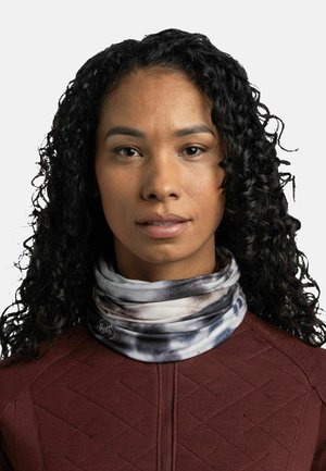 Multifunctional neck gaiter made of soft fabric, featuring a black and white tie-dye pattern. Worn with a maroon textured top.
