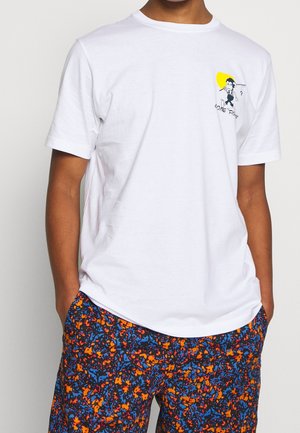 Personne portant un t-shirt blanc avec un petit pêcheur en dessin animé et le texte "Gone Fishin'" sur la poitrine, assorti à un short coloré orange, bleu et noir à motifs.