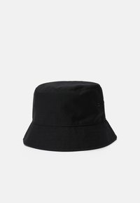 Sort bøttehat lavet af bomuld, med en bred, flad skygge og en robust, struktureret krone. Inkluderer et metaløje til ventilation.