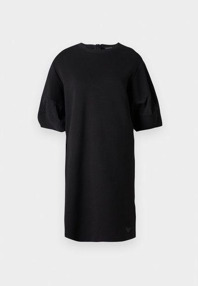 Μαύρο φόρεμα μέχρι το γόνατο με φουσκωτά μανίκια μέχρι τον αγκώνα και στρογγυλή λαιμόκοψη, με διακριτικό λογότυπο κοντά στο τελείωμα.