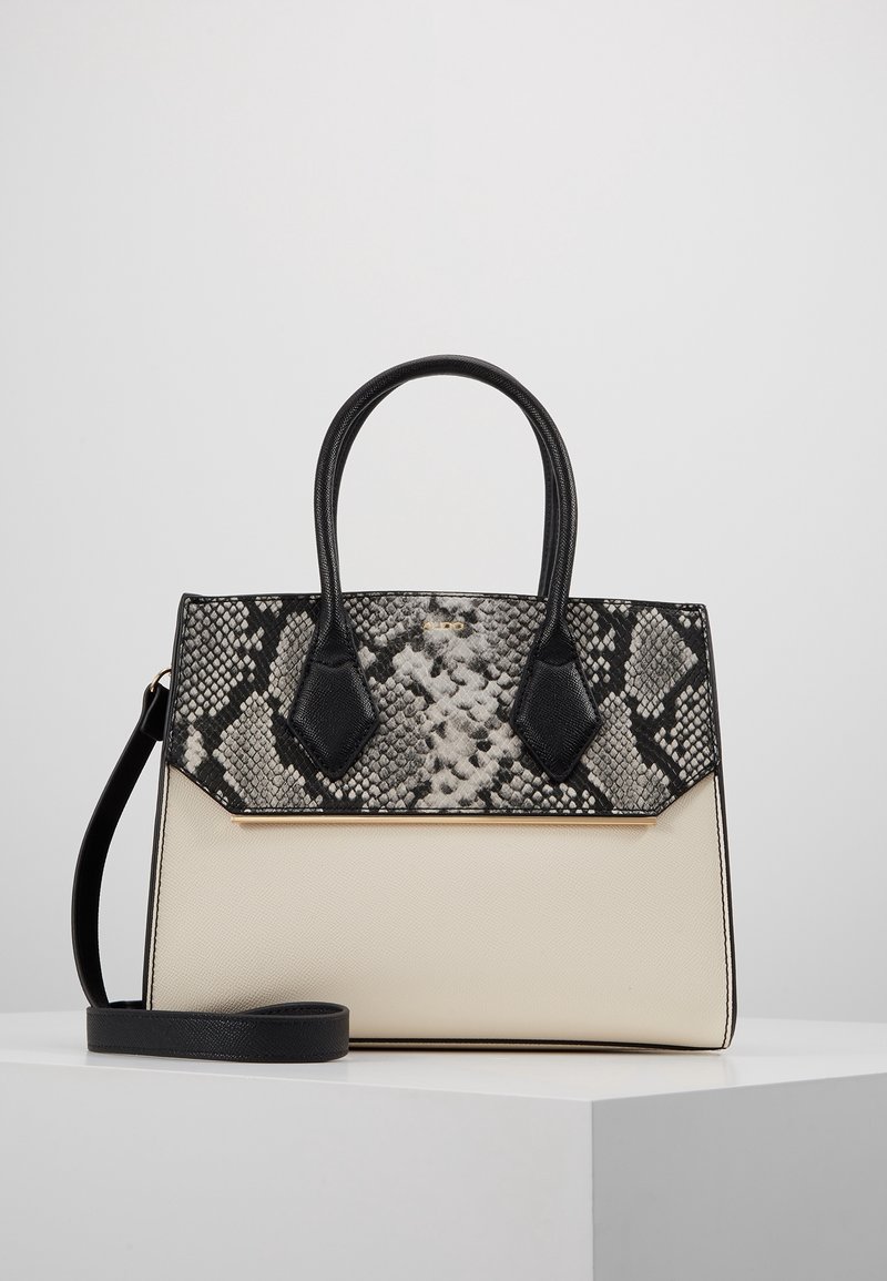Strukturerad handväska med svart och grå ormtryckstextur ovanpå, krämfärgad botten, svarta detaljer och guldfärgade beslag. Inkluderar ett avtagbart band.
