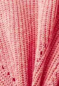 Cardigan tricoté en rose clair. Comprend une texture en tricot ouvert avec des trous subtils, un tissu doux et une coupe décontractée, drapée.
