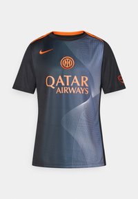 Svart idrottströja med orange detaljer, med ett vågmönster och "QATAR AIRWAYS"-logotyp. Tillverkad av lätt, syntetiskt material.
