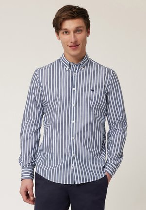 Chemise à rayures bleu et blanc avec un col, des manches longues et un ourlet arrondi. Présente un petit logo marine sur la poitrine.