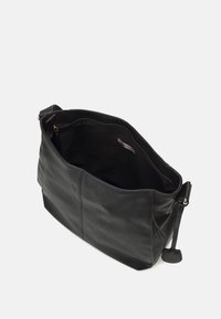 Borsa a spalla in pelle nera con una texture liscia, chiusura superiore con zip e un'etichetta interna discreta, caratterizzata da un design minimalista e senza decorazioni.