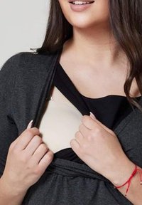 Sort og grå top med et lagdelt design, der afslører et beige beklædningsstykke under. Har en afslappet pasform og blød stofstruktur.