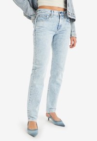 Ljust blå denimjeans med rak bendesign, hög midja, subtila blekningar och en klassisk femfickslayout.