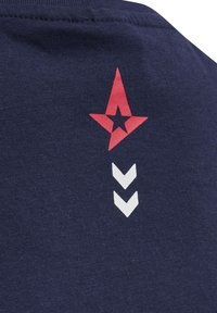 Marinblå bomullströja med röd stjärnlogotyp och vit chevron-design på baksidan. Slät struktur, tight passform.