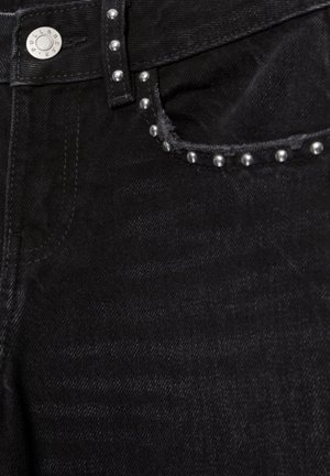 Schwarze Denim-Jeanstasche mit silbernen Metallnieten entlang der Kante und einem silbernen Knopfverschluss am Bund.