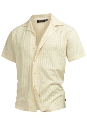 Bézs rövid ujjú, texturált, gombos ing kampnyakúval és kis, látható márkajelzéssel a gallér belsejében.