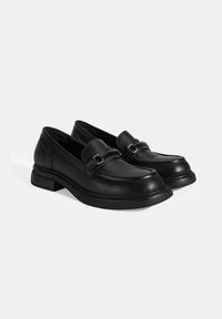 Schwarze Lederloafers mit abgerundeter Spitze, schlankem Design, Riemen mit Metallschnalle, niedrigem Blockabsatz und glatter Oberfläche.