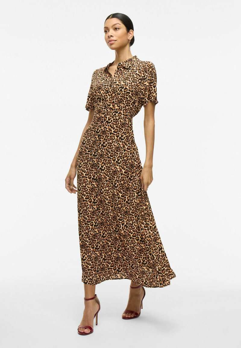 Robe maxi à imprimé léopard avec manches courtes, fermeture à boutons, tissu doux et silhouette fluide, associée à des sandales à talons bordeaux.