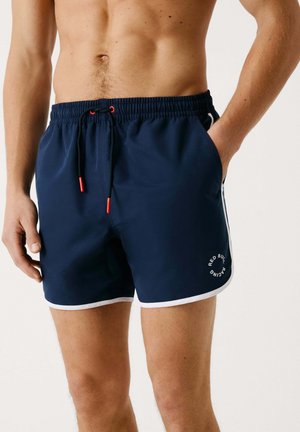Marineblaue Schwimmshorts mit einem Kordelzugbund, weißen Akzenten, seitlichen Taschen und einem Logodetail. Hergestellt aus leichtem, schnell trocknendem Material.