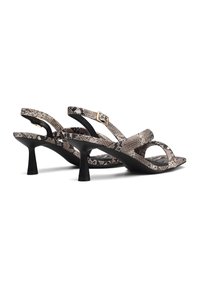 Schwarz-goldene, hochhackige Sandalen mit Schlangenhautmuster und überkreuzten Riemen. Glatte Textur, neutrale Farbtöne.