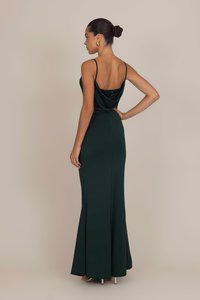 Long, fitted evening dress in dark green, featuring a draped back, thin straps, and a subtle lace accent at the back neckline. Smooth fabric texture.