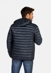 Veste matelassée bleu marine avec un design en quilting horizontal et une capuche. Fabriquée en matériau léger et brillant, elle dispose d'un cordon de serrage réglable au niveau du cou.