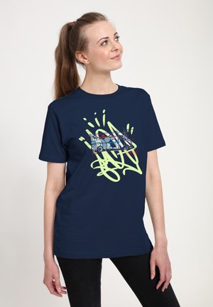 Námořnická modrá bavlněná tričko s grafikou stylizovaného dodávkového auta a zelenými graffiti podobnými akcenty. Krátké rukávy a pohodlný střih.