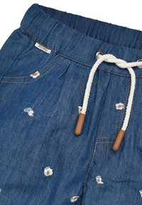 Jeans mit elastischem Bund, weißem Kordelzug mit braunen Enden und bestickten Blumenmustern in Weiß und Braun auf der gesamten Hose.