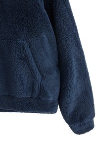 Navy blue fleece pullover with a soft, textured surface, featuring a front pouch pocket and ribbed hem and cuffs.