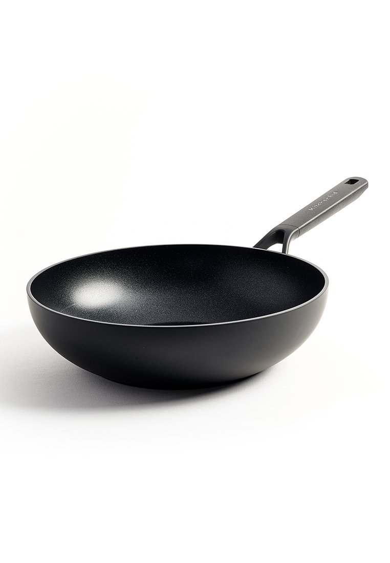 Schwarzer, antihaftbeschichteter Wok mit einem glatten, geschwungenen Design. Verfügt über einen stabilen Griff, abgerundete Kanten und ein mattes Innenfinish.