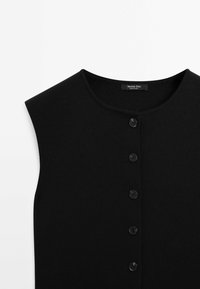 Black sleeveless top made of ribbed fabric featuring a round neckline and six black buttons down the front. Brand label visible inside.