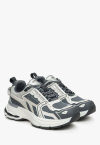 Buty sportowe z szaro-białą siateczką na wierzchu, wzmocnionym noskiem, wyściełanym kołnierzem i teksturowaną podeszwą. Wyposażone w sznurówki i pętelkę z tyłu.