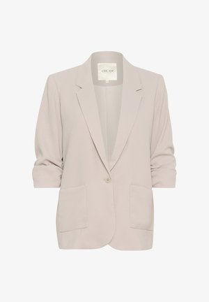 Vaalea harmaa bleiseri, joka on valmistettu sileästä kankaasta. Mallistossa on yksittäinen napin sulkeminen, kaksi etutaskua ja ¾-hihat, joissa on käärittävät hihansuut.