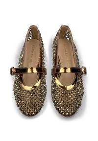 Un paio di ballerine Mary Jane dorate e brillanti, con dettagli in rete e una fascia con fibbia, viste dall'alto su uno sfondo bianco.
