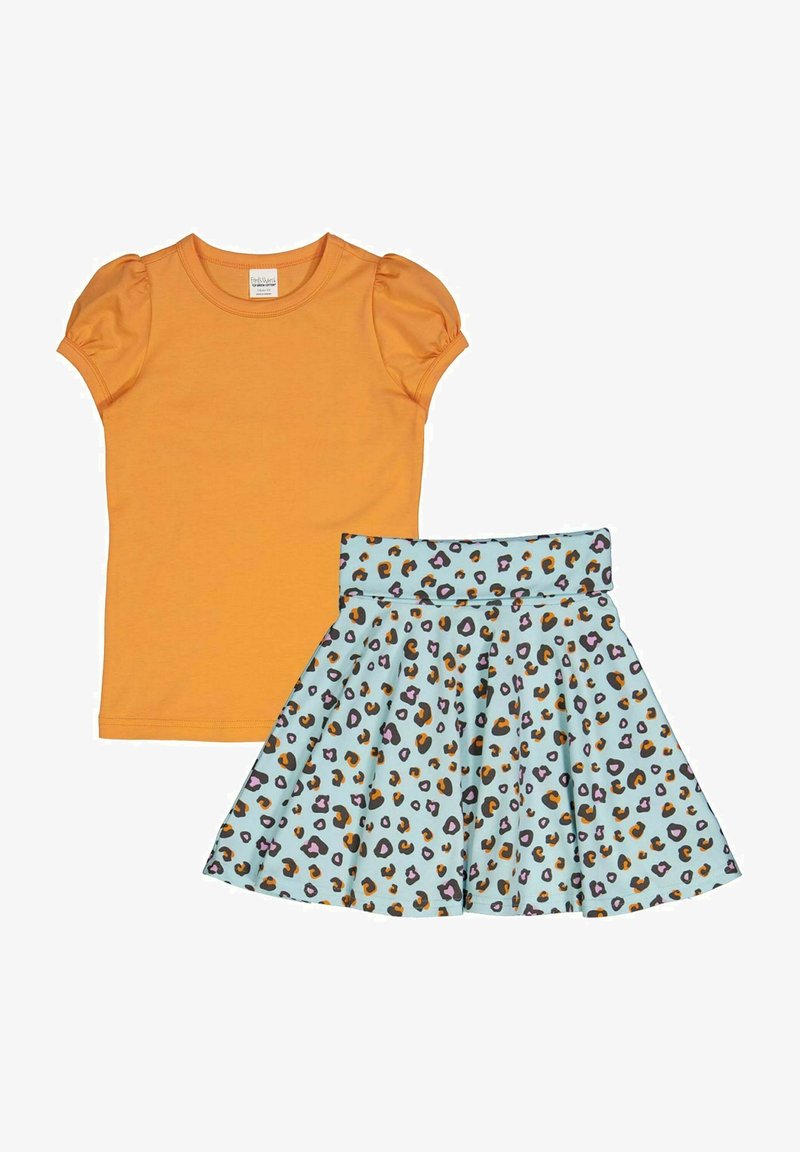 Oranžové tričko s krátkým rukávem a nabíranými rukávy, spárované se světle modrou sukní s vícebarevným leopardím potiskem.