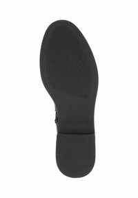 Semelle de chaussure en caoutchouc noir avec un motif de texture antidérapant et un talon rond. Bord lisse avec une base plate et large pour plus de stabilité.