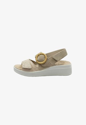 Sandalo beige open toe con suola a zeppa, cinturini regolabili in velcro e una grande fibbia tonda dorata sul lato.