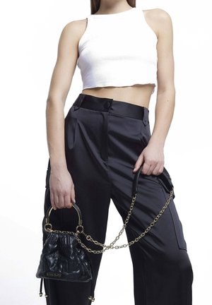 Zwarte handtas van nepleer met een geplooid ontwerp, gouden kettingriem en een afgeronde handgreep, gecombineerd met zwarte hoge taillebroek en een wit cropped topje.