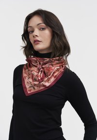 Silk tørklæde i blush pink med blomstermønster, trekantet design og en knyttet accent. Har en glat, blank tekstur og kontrasterende kanter.
