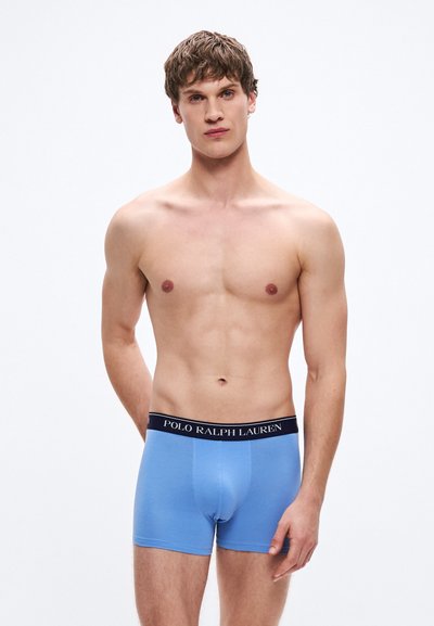 Boxerși albaștri din material moale, cu o talie neagră pe care este inscripționat logo-ul "POLO RALPH LAUREN". Textură netedă și design ajustat.