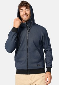Marineblauer Reißverschluss-Hoodie aus strukturiertem Stoff, mit hohem Kragen, Kapuze mit Kordelzug und Kängurutaschen, sowie gerippten Bündchen und Saum.