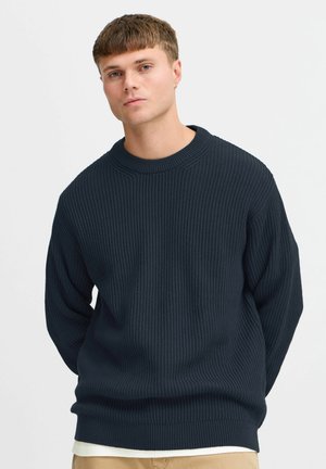 Navy ribbed knit sweater with a round neckline, long sleeves, and a relaxed fit, featuring textured surface and a simple design.