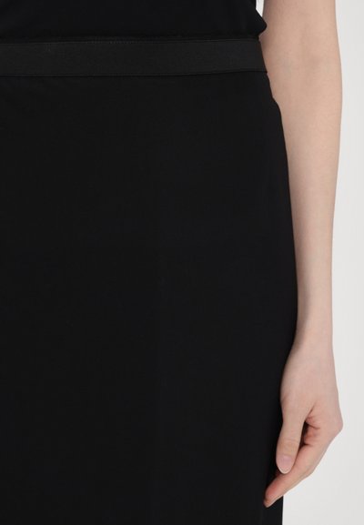 Schwarzes Kleid aus glattem, dehnbarem Stoff mit taillierter Passform. Ein passender schwarzer elastischer Bund betont die Taille.