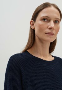 Marineblau gestrickter Pullover mit texturierter Oberfläche, scoop-Halsausschnitt und gerippten Bündchen. Der Pullover hat eine lässige Passform und erhöhte Nähte an den Schultern.