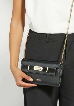 Black leather crossbody bag with a textured surface, gold hardware, and a front clasp. Features a chain strap and embossed brand logo.