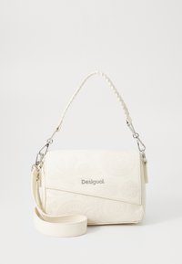 Bijela crossbody torba s reljefnim cvjetnim uzorcima, tkanom drškom, srebrnim hardverom i odvojivim remenom. Teksturovan materijal od umjetne kože.
