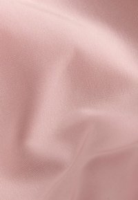 Tela de color rosa claro con una superficie texturizada, que presenta pequeñas hendiduras uniformemente espaciadas. El material parece suave y ligeramente arrugado.